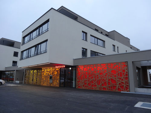Dekorplatte zur Außenraumgestaltung - RAIFFEISEN BANK HEIMBERG - Bruag Design Factory AG - wandmontiert / hintergrundbeleuchtet / HPL