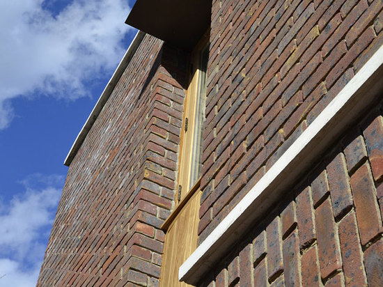 Das dunkle Braun, gesprenkelte, WestHoathly Sharpthorne Ziegelstein façades wird mit Abschnitten der goldenen Eiche um Türen und Fenster vermischt. Die Ziegelsteine werden in drei eindeutige Abbind...