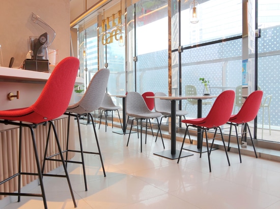 Ta Up Chairs von TOOU, umgeben von der bunten Atmosphäre des Elle Café in Shanghai.