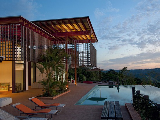 Ein Holzgitter filtert die Sonne, aber nicht die Ansichten von diesem Haus in Brasilien