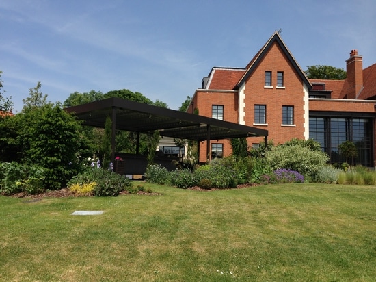 Wohnzimmer im Freien mit bioklimatischer Pergola in einem Landhaus in England