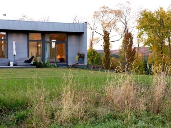 Das hohe Fenster ist mit einem benutzerdefinierten Dachsupper ausgerichtet. Bei Regen fällt ein Wasservorhang vom Speigatt in ein Auffangbecken. Design von: Art Forms Architecture, Konstruktion von...