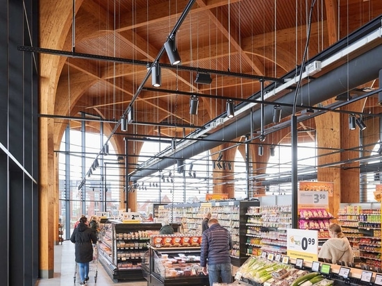 Elegante kathedralenähnliche Holzsäulen stützen ein Vordach über diesem neuen Supermarkt