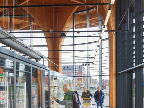 Elegante kathedralenähnliche Holzsäulen stützen ein Vordach über diesem neuen Supermarkt