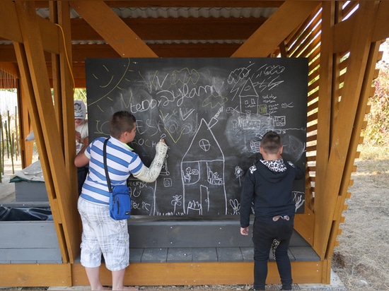 kleine Bänke und eine Anschlagtafel definieren den Kindergartenbereich, für Gebrauch in den Werkstätten und für Spaß