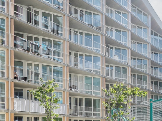 glassed Räume und dreieckige Balkone heben ein Gefühl der Offenheit in Richtung zum Hof hervor