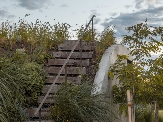 Ein Haus, das sich aus dem Boden erhebt und einen dreistufigen Garten bildet