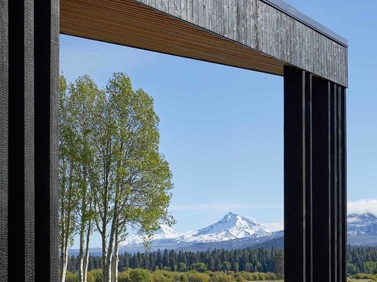 Ein warmes Holz-Interieur kontrastiert mit der schwarz verkohlten Zedernholz-Außenseite dieser Ranch-Lodge in Oregon