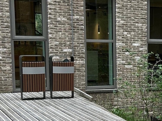 Málaga-Wertstofftrennbehälter mit WPC (Wood Plastic Composite) Kunstholzlamellen und einem Rahmen aus verzinktem Stahl im Innenhof des World Trade Centre in den Niederlanden.